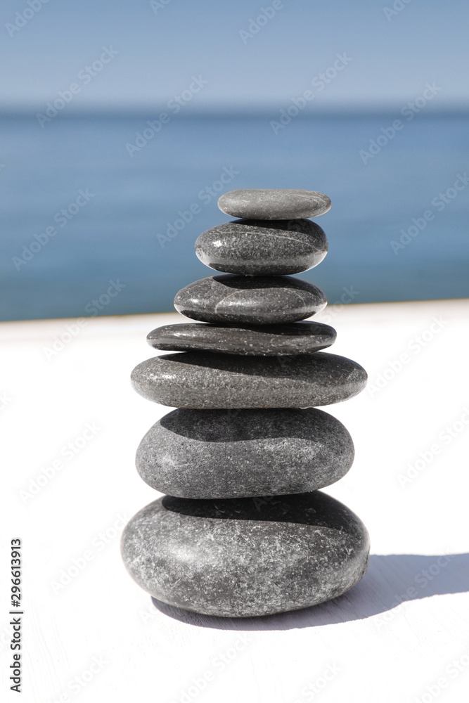 Stack of stones on wooden pier near sea. Zen concept Stack of stones on wooden pier near sea. Zen concept