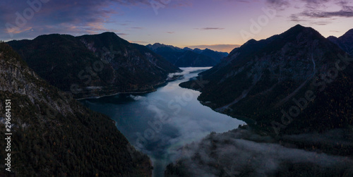 lake plansee at dawn morning with ground fog at fall autumn in tirol
