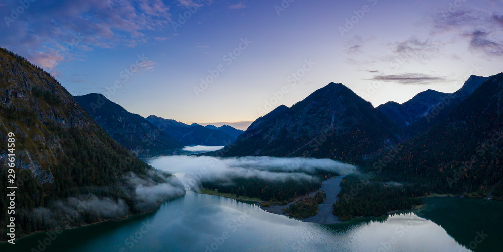 aerial view of heiterwanger see to lake plansee at morning dawn with foggy clouds