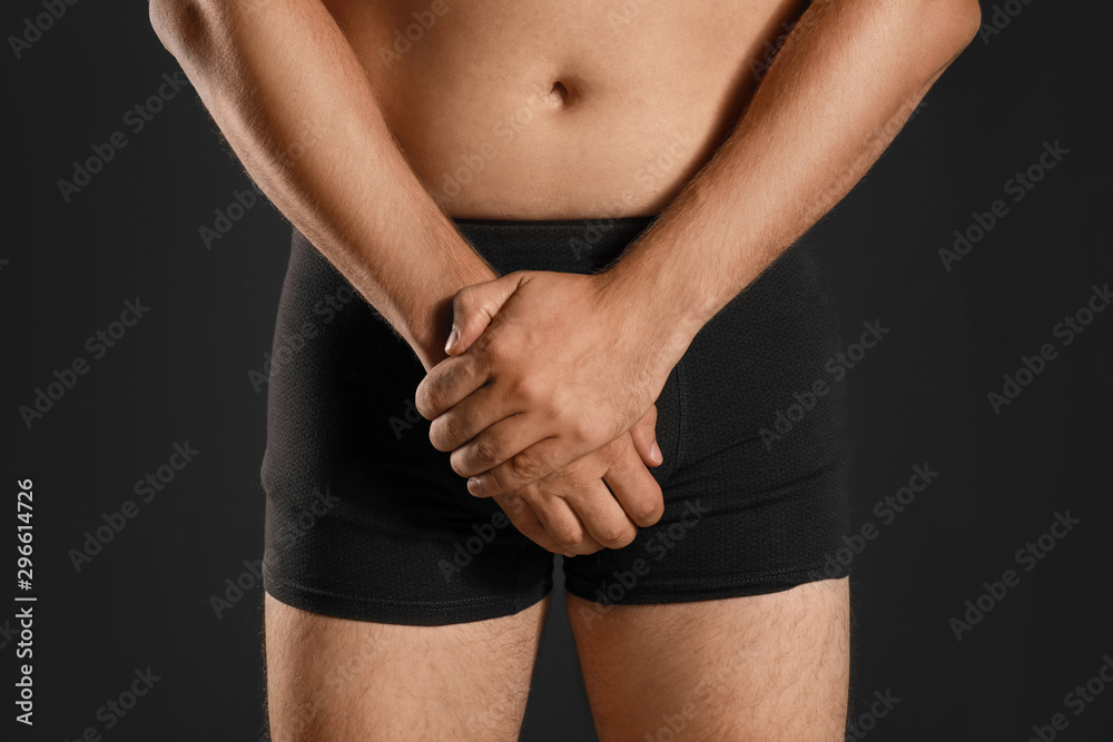 Man suffering from pain on black background, closeup. Urology problems