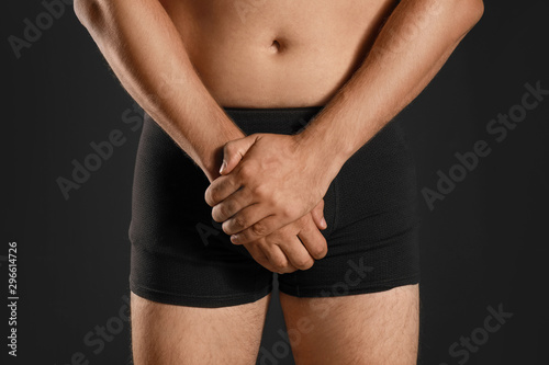 Man suffering from pain on black background  closeup. Urology problems