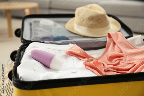 Suitcase with deodorant and clothes at home