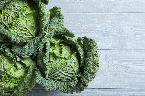 Fresh green savoy cabbages on grey wooden table, flat lay photo