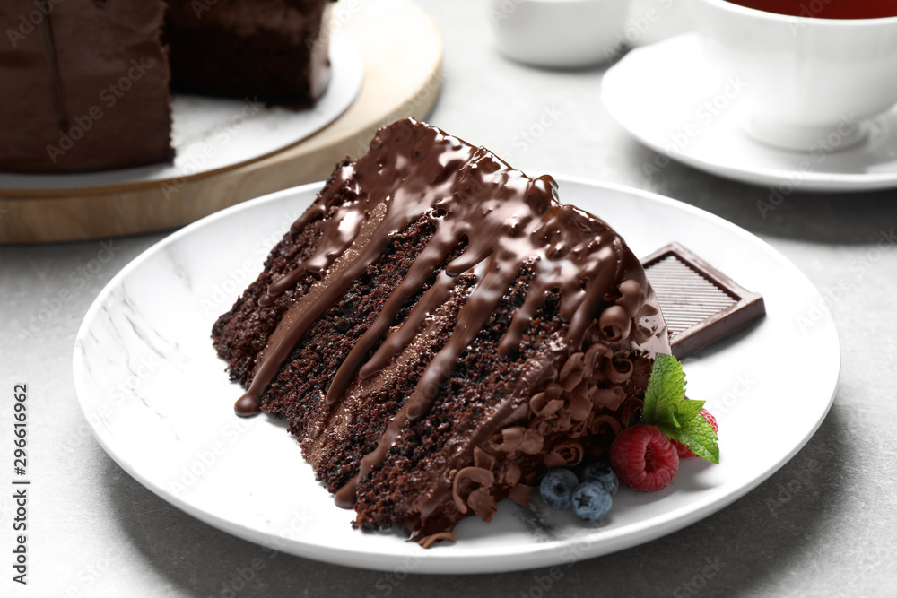 Piece of delicious chocolate cake decorated with fresh berries served on white table Piece of delicious chocolate cake decorated with fresh berries served on white table