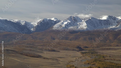 Beautiful panoramic shot of a valley with winding river and row of the Altai mountains on horizon in Siberia. photo