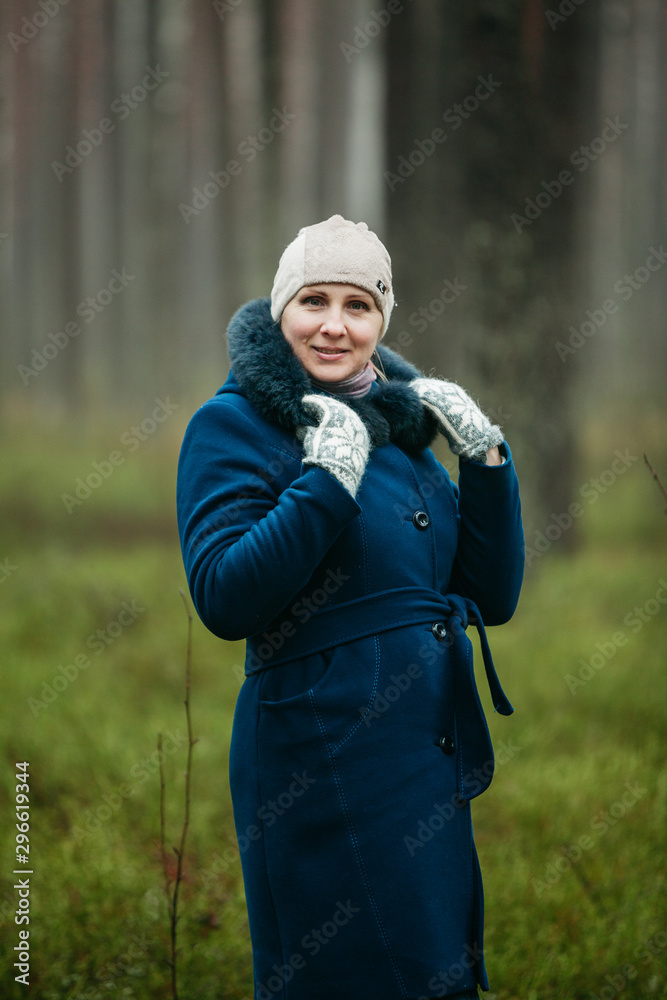 Portrait of cute European Latvian woman looking happy and smiling Wearing faux fur and dark blue coat and headpiece Portrait of cute European Latvian woman looking happy and smiling Wearing faux fur and dark blue coat and headpiece
