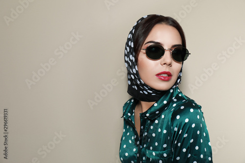 Beautiful woman in stylish sunglasses on beige background. Space for text