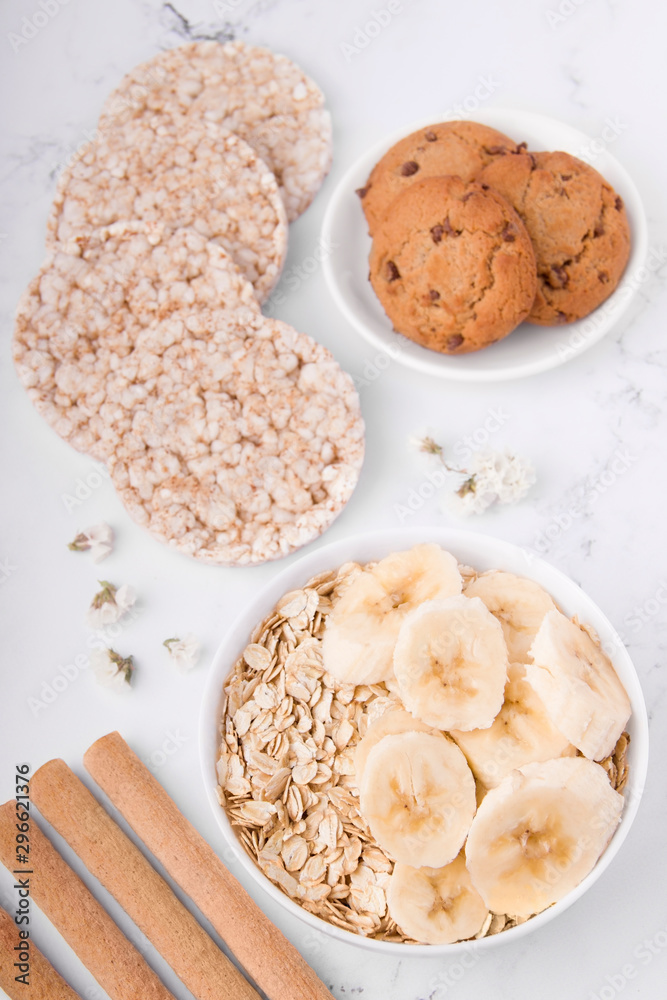 Breakfast of crispy bread cookies, oatmeal with banana on a light background