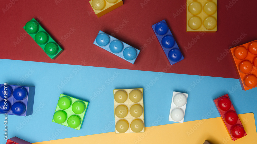 Toy bricks. Colorful plastic building blocks flat lay. Toys background. Child developing game. Multi-colored cubes.