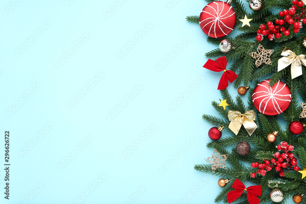 Christmas tree branches with toys and red berries on blue background Christmas tree branches with toys and red berries on blue background