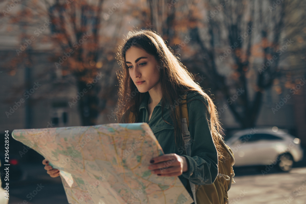 Naklejka premium Woman tourist exploring city while holding map