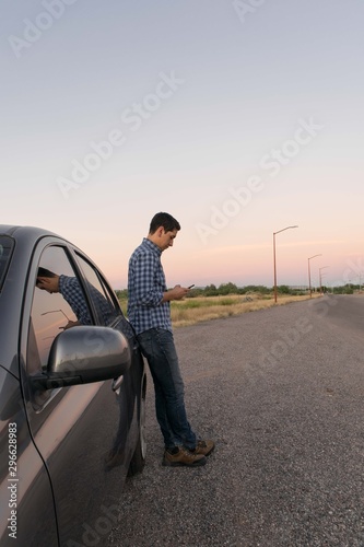 Standing man next to a car at the afternoon