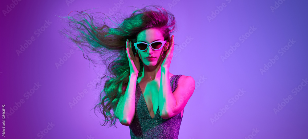 Fototapeta High Fashion. Party disco girl with pink neon hairstyle dance. Sensual woman in Colorful uv Light. Vibrant fashionable creative Style. Night Club music vibes, dancing. gel filter lighting, neon color