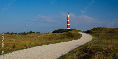 Path leading through the dunes towards vuurtoren, lighthouse of Ameland