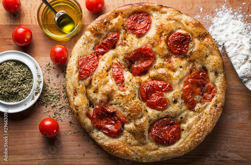 Bari-style focaccia bread, focaccia barese, focaccia with cherry tomatoes, olive oil and oregano. Top view.