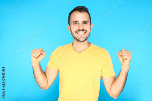 Portrait of young happy man on blue background