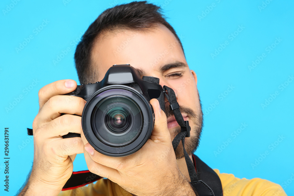 Young photographer with camera on blue background Young photographer with camera on blue background