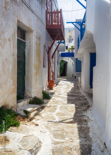 Fototapeta Naklejka Na Ścianę i Meble -  Narrow streets and blue windows with white buildings in Mykonos Greece