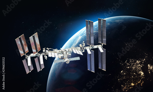 Fototapeta Naklejka Na Ścianę i Meble -  ISS space station on orbit of the Earth planet. Blue light on background. Elements of this image furnished by NASA