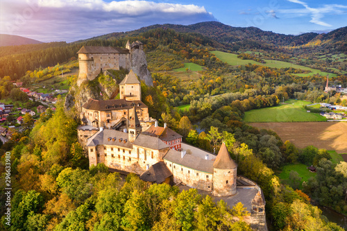 Orava castle - Oravsky Hrad in Oravsky Podzamok in Slovakia. Medieval stronghold on extremely high and steep cliff by the Orava river. Aerial view in sunset light