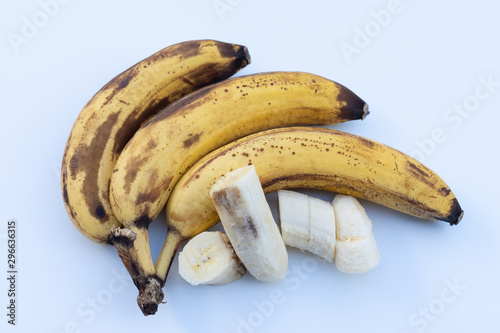 Over ripe bananas isolated on white background. Bunch of overripe banana and peeled sliced.