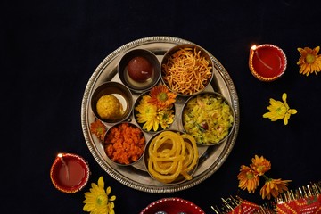 Homemade Diwali foods- snacks and desserts on festive background