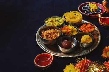Homemade Diwali foods- snacks and desserts on festive background