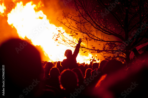 Crowds of people gather in front of huge flames from bonfire for bonfire night in Rye, East Sussex, uk photo