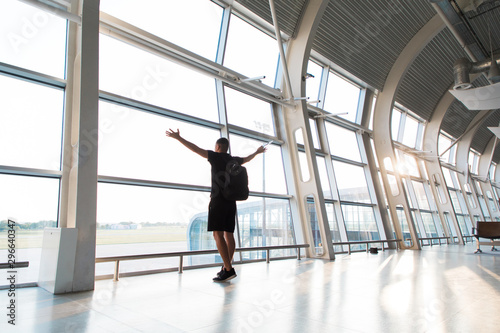 Silhouette of the young man with raised hands at the airport. Traveler leaves to the gate. © F8  \ Suport Ukraine