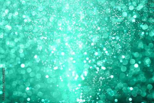 Shiny green defocused glitter background.