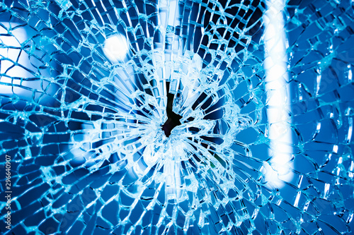 Broken glass window. Blue background. Closeup. photo