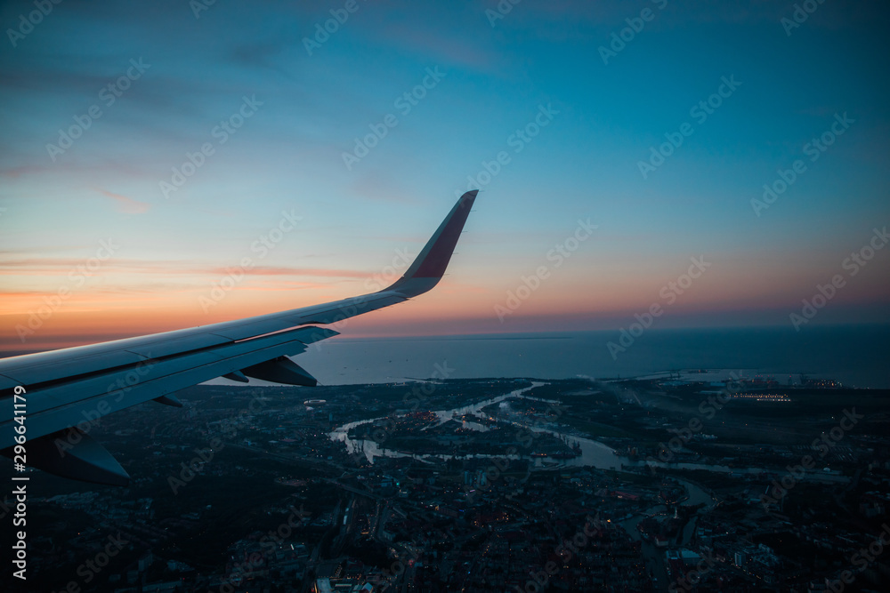 Fototapeta premium View on the sunset and airplane wing from the inside.