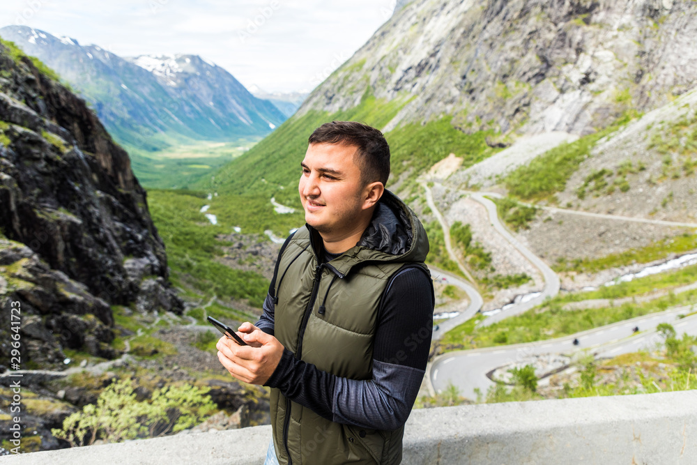 Tourist young man using cellphone in nature. Tourist young man using cellphone in nature.
