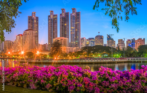 Lake in City Park under Skyscrapers at Night. Benjakiti Park in Bangkok, Thailand photo