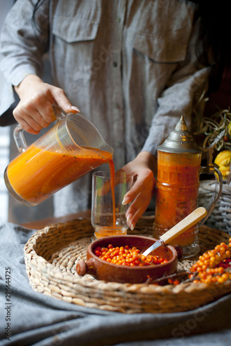 Brown table with common sea buckthorn drink and berreis Homemade sea buck thorn liqueur, Hippophae rhamnoides, on the wooden board.  Brown tabl sea buckthorn pumpkin smoothie, fresh vegan autumn drink photo