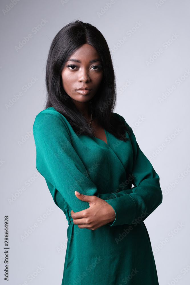 The picture of elegant african woman in dark green dress looking at the camera. The picture of elegant african woman in dark green dress looking at the camera.