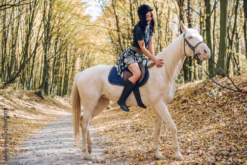 beautiful young girl riding a horse in the autumn forest © Олег Кошевський