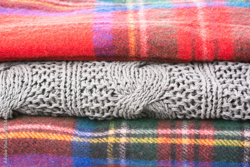 Stack of cosy winter wool blankets in tartan red, blue, grey colors, selective focus Stack of cosy winter wool blankets in tartan red, blue, grey colors, selective focus