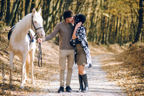 Beautiful young couple walking in the autumn forest. Horseback riding in the autumn forest. © Олег Кошевський