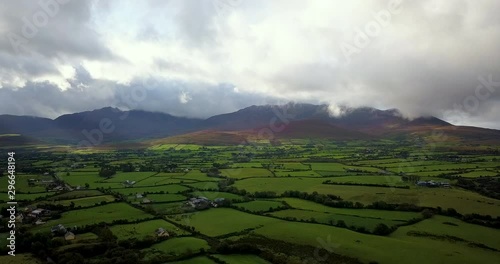 drone footage of the landscape and mountains surrounding killarney national park in autumn showing cloudy skies and green fields
