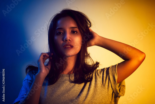Beautiful woman face. Yellow and blue light color. Double light colors of potrait.