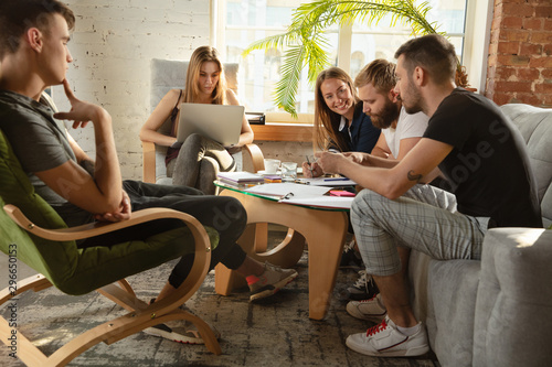 Group of young caucasian office workers meeting to discuss new ideas. Creative meeting. Teamwork and brainstorming. Men and women meet in office to plan their future working. Business concept.