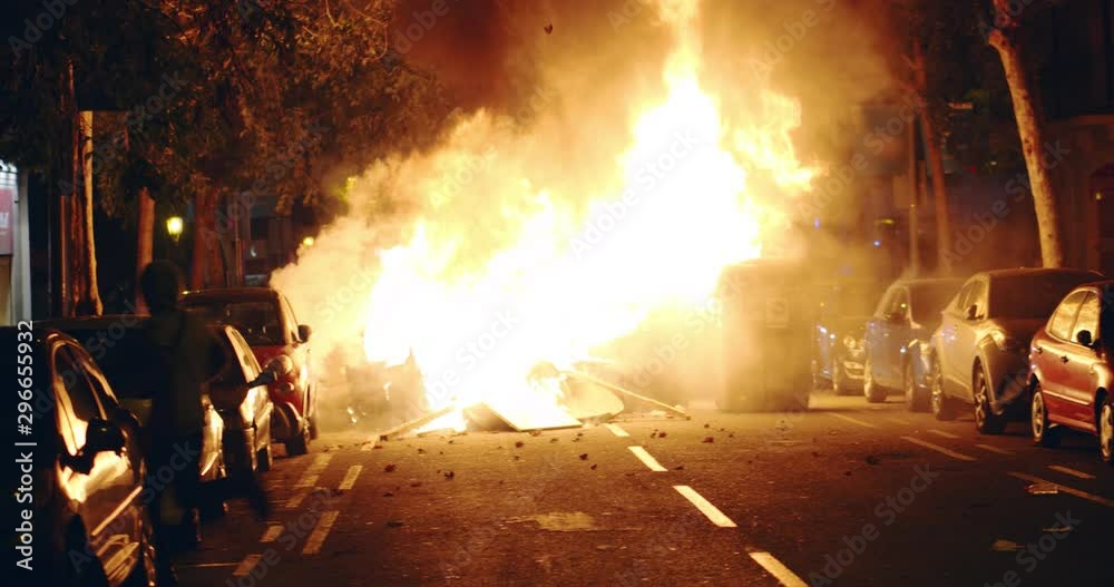 Young rebel riot revolutionary anarchist stands on trash during demonstration