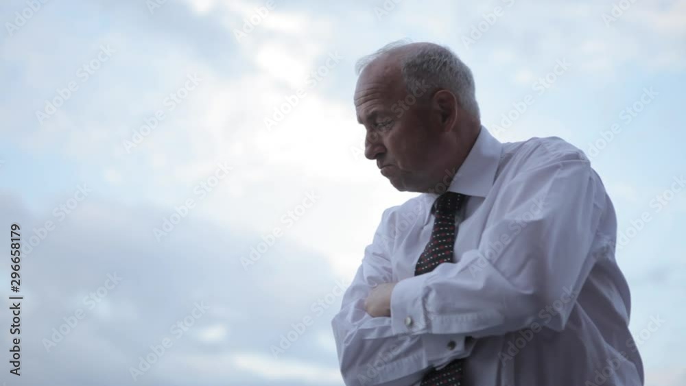 Portrait of a confident mature businessman against a cloudy blue sky