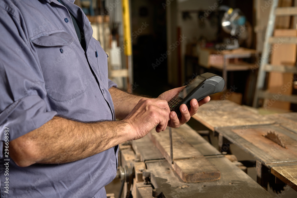 Man with blue overalls in carpentry using credit card. bank payment Man with blue overalls in carpentry using credit card. bank payment