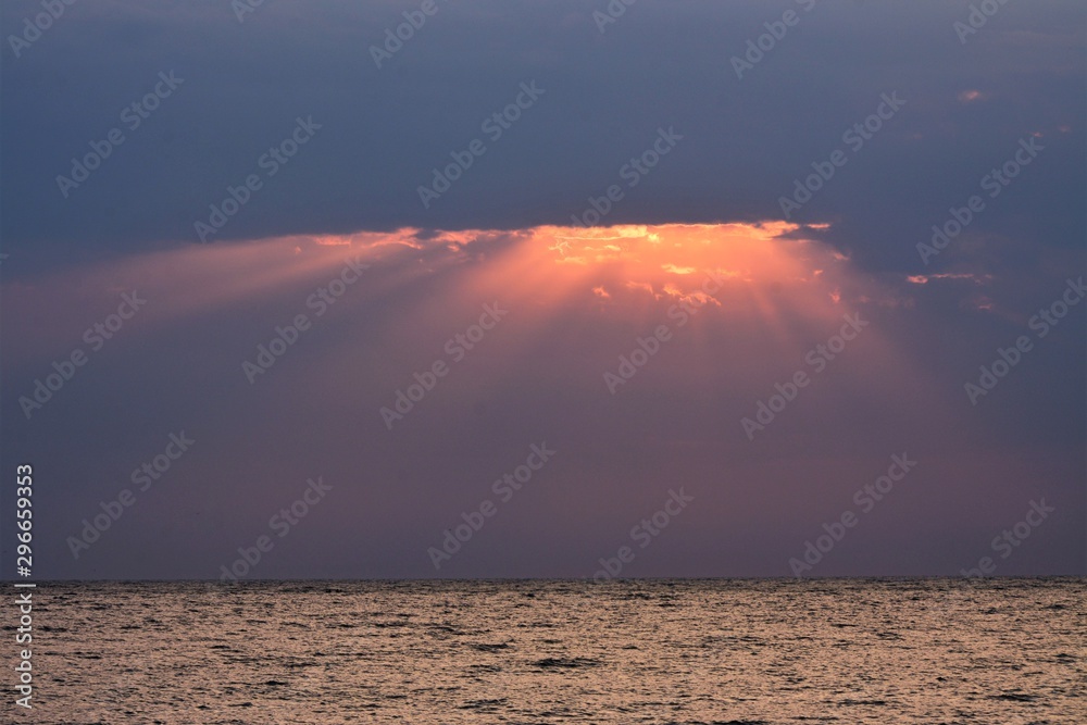 sunbeams among the clouds above the sea