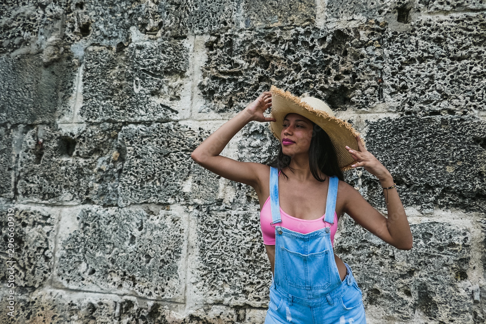 Beautiful and sexy latin woman dressed in hat and shorts. Fashion model in jeans. Outdoor Park Beautiful and sexy latin woman dressed in hat and shorts. Fashion model in jeans. Outdoor Park