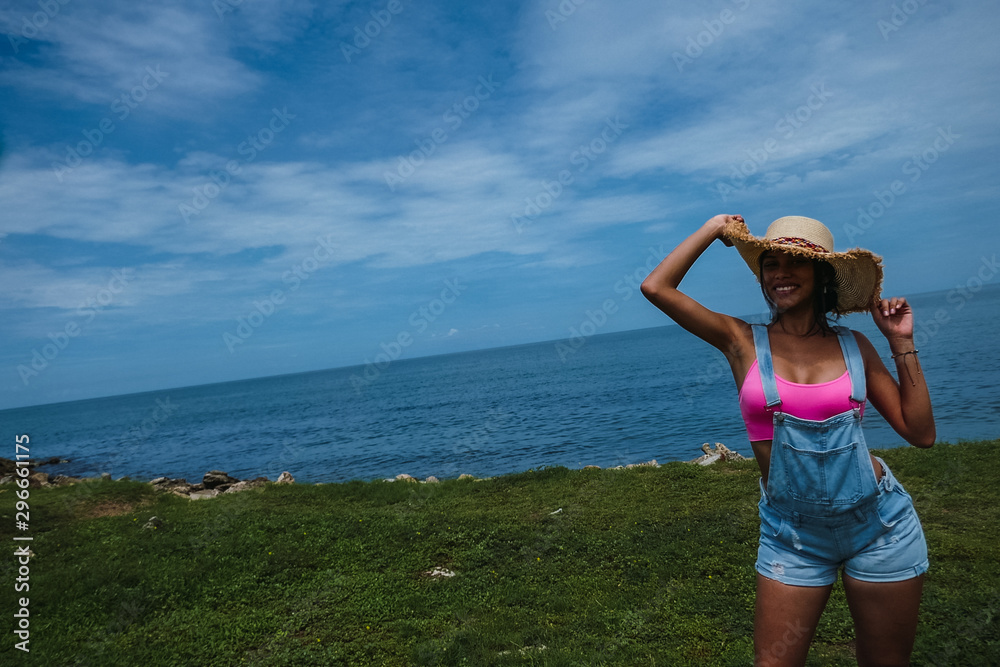 Outdoor fashion photo portrait of a beautiful young, tender and modern Latina model posing and smiling during summer trips. Outdoor fashion photo portrait of a beautiful young, tender and modern Latina model posing and smiling during summer trips.