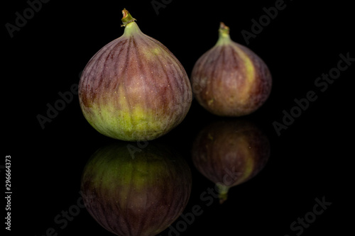 Group of two whole sweet purple fig isolated on black glass