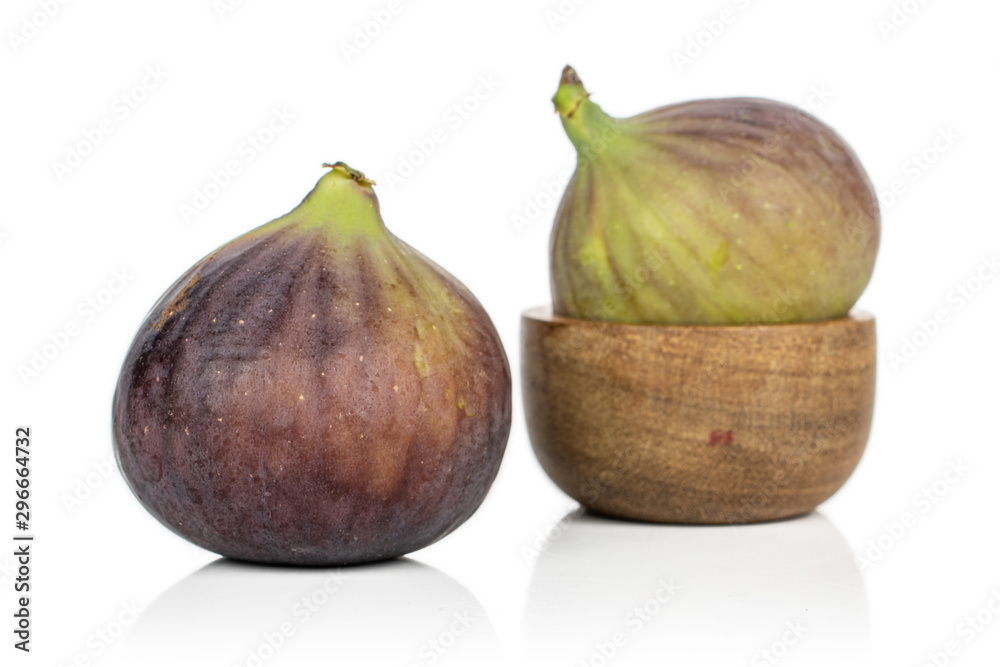 Group of two whole sweet purple fig in bamboo bowl isolated on white background Group of two whole sweet purple fig in bamboo bowl isolated on white background